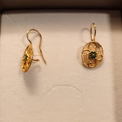 Brincos dourados em filigrana com flor verde numa caixa branca