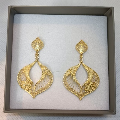 Brincos dourados com design em forma de folhas e flores numa caixa cinza acolchoada branca