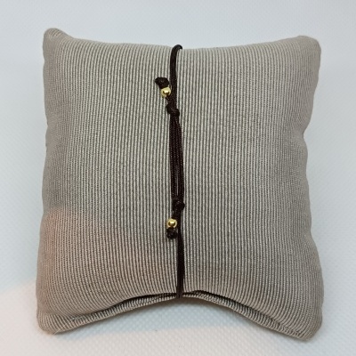 Almofada cinzenta com corda preta e contas douradas