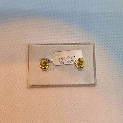 Brincos pequenos de ouro amarelo em cartão branco com etiqueta