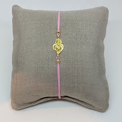 Pulseira com fio rosa e pendente dourado em almofada cinza canelada