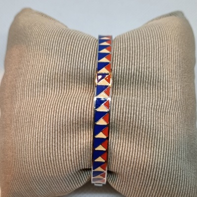 Pulseira colorida em padrão geométrico sobre almofada bege