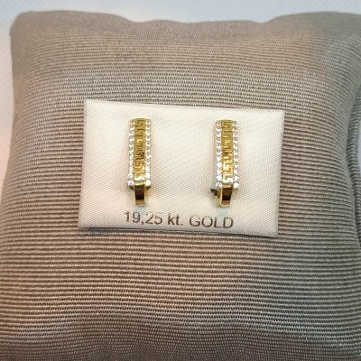 Brincos de ouro 19,25 kt com brilhantes em base branca sobre tecido bege