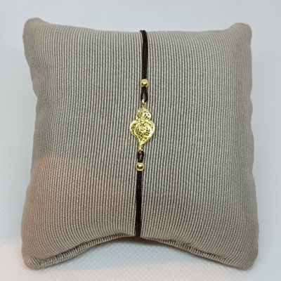 Pulseira dourada com cordão castanho em almofada cinza