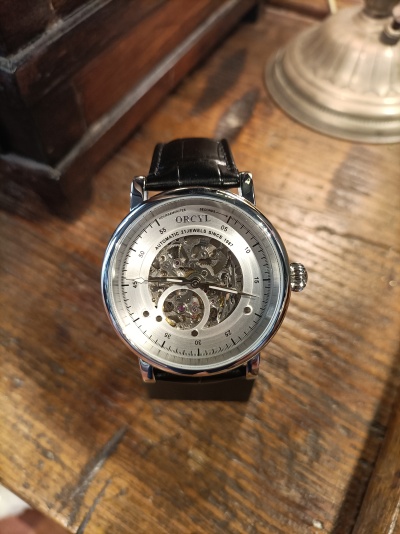 Relógio ORCYL com bracelete de couro preto e mostrador com mecanismo visível