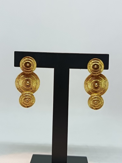 Brincos dourados com design de três círculos texturizados num suporte preto