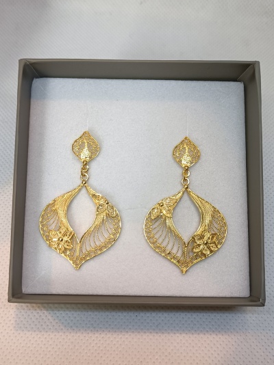 Brincos dourados com design em forma de folhas e flores numa caixa cinza acolchoada branca