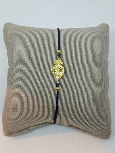 Pulseira com fio e pendente dourado em almofada bege