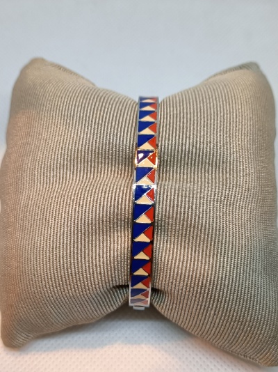 Pulseira colorida em padrão geométrico sobre almofada bege