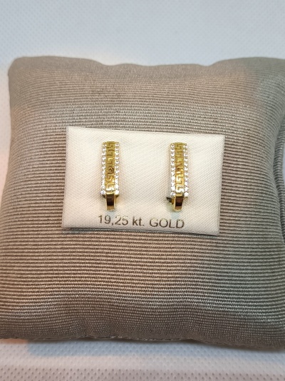 Brincos de ouro 19,25 kt com brilhantes em base branca sobre tecido bege