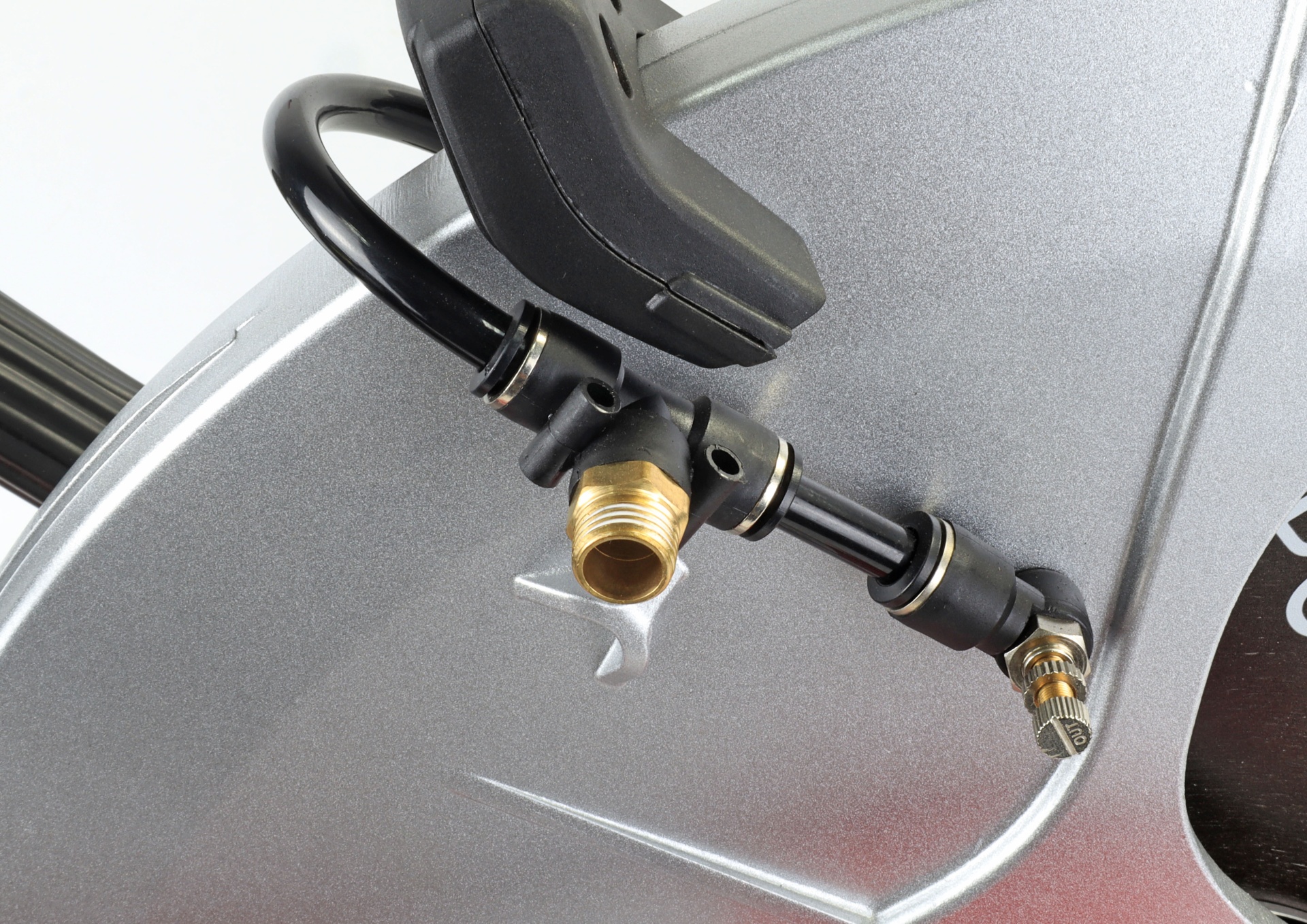 Peça metálica prateada com tubos e válvula conectores pretos e dourados