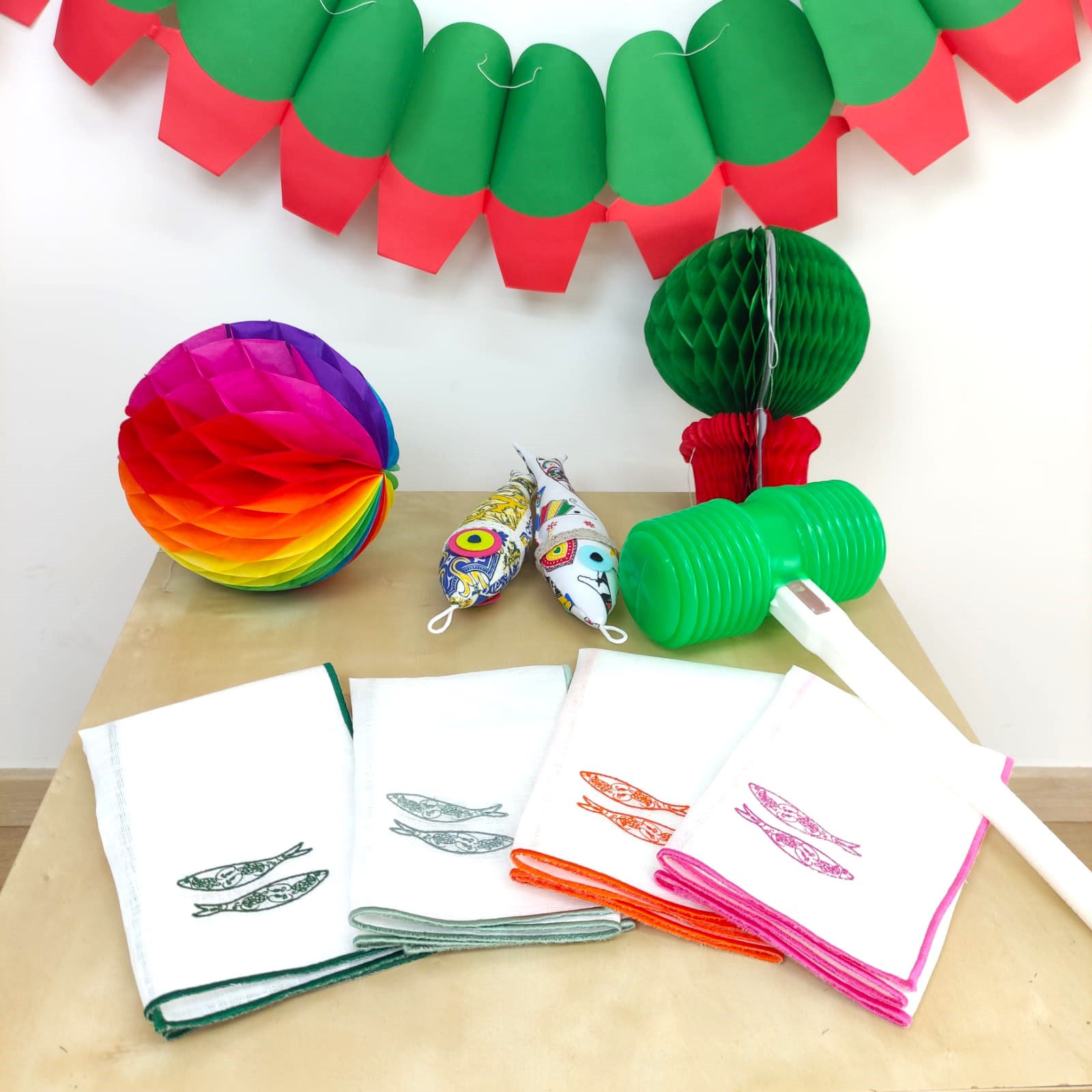 Toalhas brancas com bordas coloridas e decoração festiva em papel