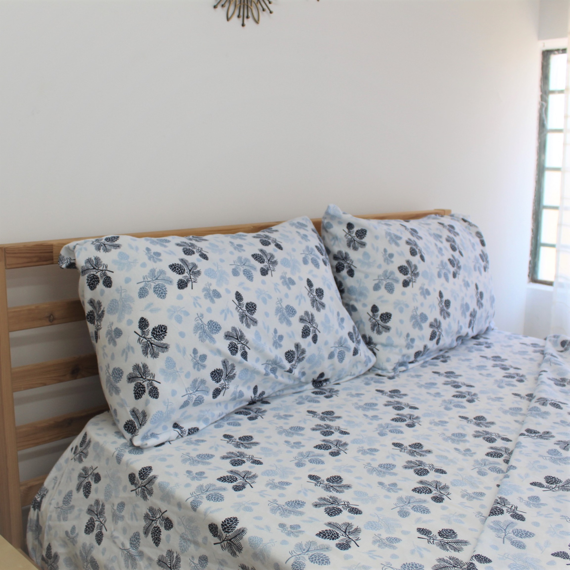 Jogo de Lençois Flanela Pinha Azul Jogo de cama azul com padrão de folhas e cama de madeira clara