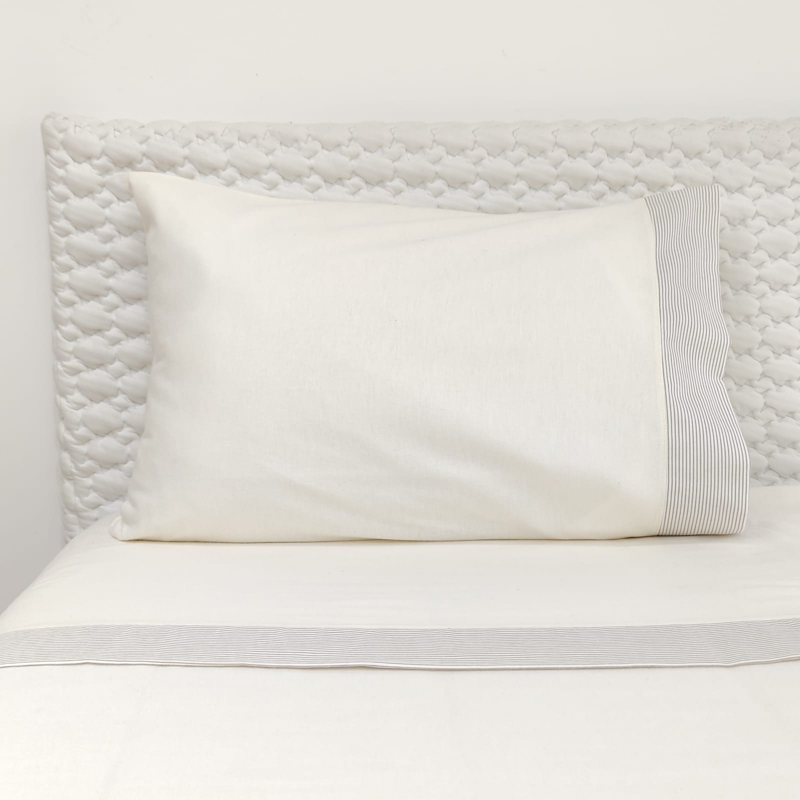 Jogo de Cama Flanela Pérola Riscas Almofada branca com detalhe riscado em cama com cabeceira acolchoada branca
