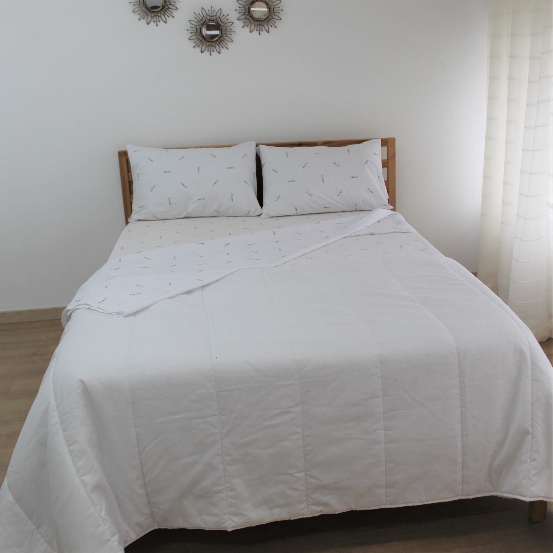 Lençol Hospitalar com Estampado de Iniciais ou logo Cama de casal com edredão branco e almofadas brancas com pequenos desenhos finos