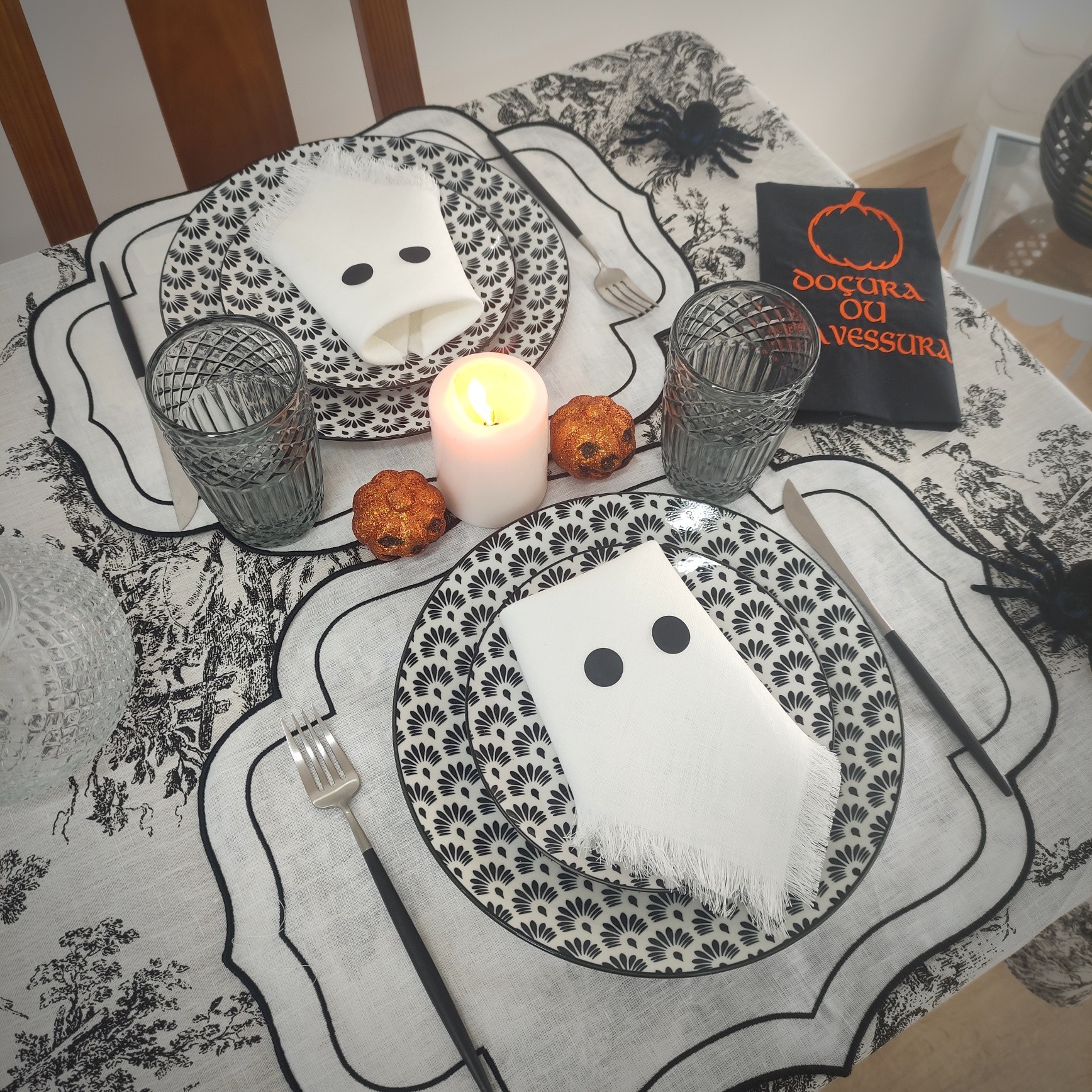 Mesa posta com decoração preta, branca e cinzenta para Halloween.