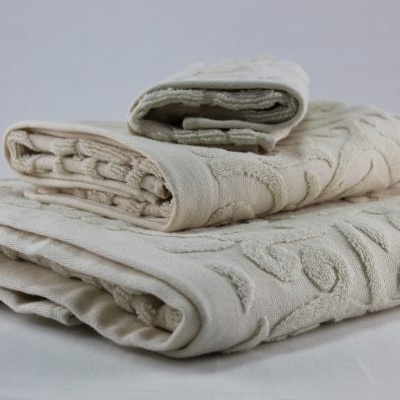 Conjunto de toalhas creme texturizadas empilhadas em fundo branco