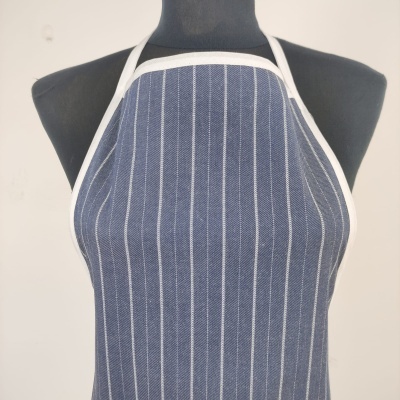 Avental azul escuro riscado com bordas brancas num manequim preto