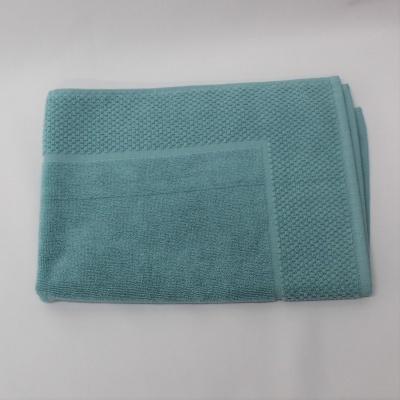 toalha azul turquesa em algodão com textura e padrão de pequenos quadrados