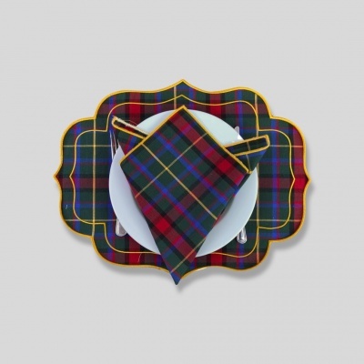 Guardanapo e base de prato xadrez colorido sobre prato branco com talheres em fundo cinzento