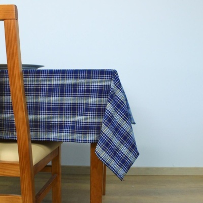 Toalha de mesa azul de padrão xadrez sobre mesa de madeira com cadeira