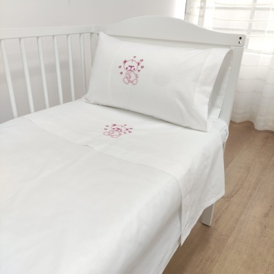 Conjunto de roupa de cama infantil branco com bordado de ursinho cor-de-rosa em berço branco