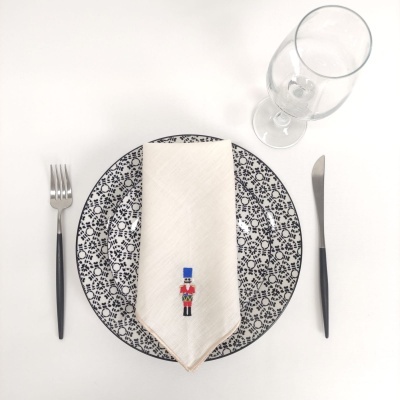 Conjunto de jantar com prato decorado, guardanapo com bordado de soldado, talheres e copo de vidro