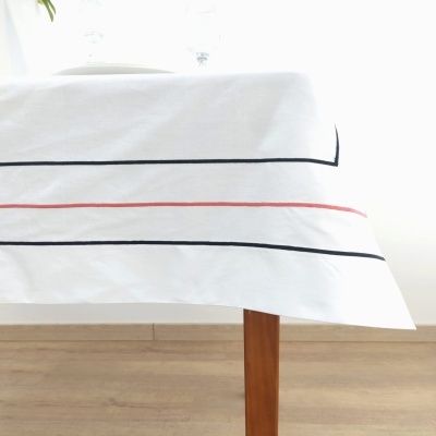 Toalha de mesa branca com riscas horizontais finas em preto e vermelho sobre mesa de madeira