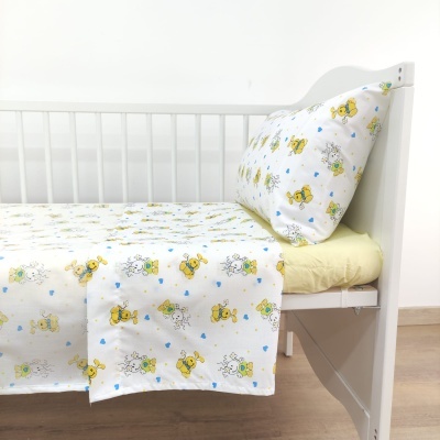 Cama de criança branca com lençóis e fronha coloridos e colchão amarelo claro