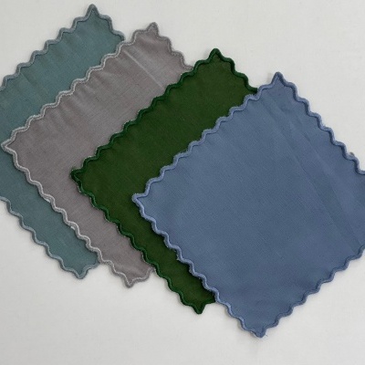 Quatro panos de microfibra em azul claro, cinzento, verde e azul com bordas onduladas