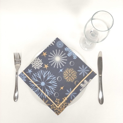 Guardanapo estampado com talheres e copos sobre toalha branca