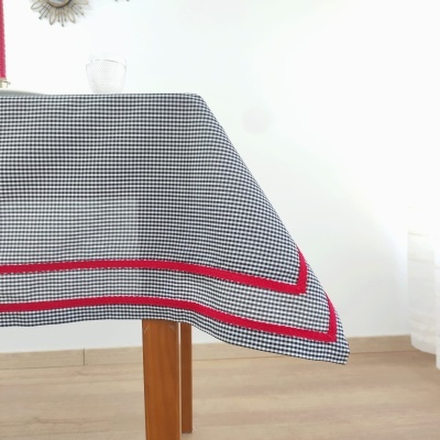 Toalha de mesa em padrão preto e branco com faixas vermelhas na borda