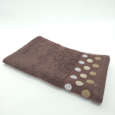 Toalha castanha com padrão de círculos dourados e prateados