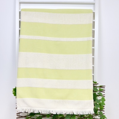 Toalha riscada branca e verde claro com franjas pendurada