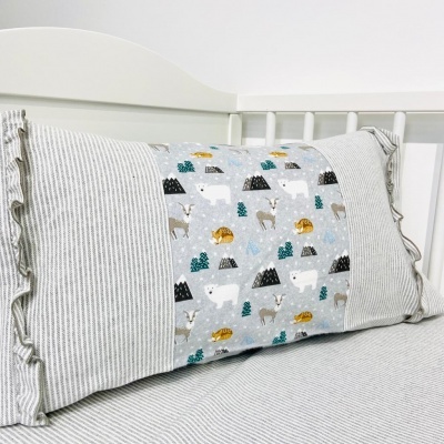Almofada retangular com estampado de animais e riscas em berço branco