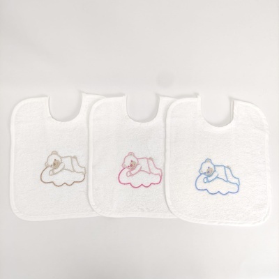 Três babetes de bebé brancos com ursinhos bordados em castanho, rosa e azul.