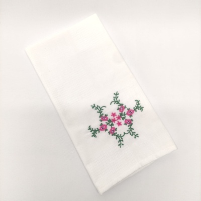 Guardanapo de tecido branco com bordado floral rosa e verde