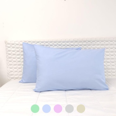 Duas almofadas azuis claras retangulares sobre cama com colchão branco e encosto branco texturado