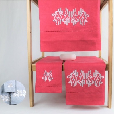 Jogo de toalhas cor-de-rosa com bordado branco em estrutura de madeira