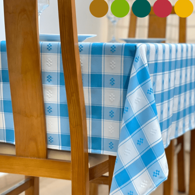 Toalha de mesa xadrez azul e branco com detalhes florais, mesa e cadeiras de madeira