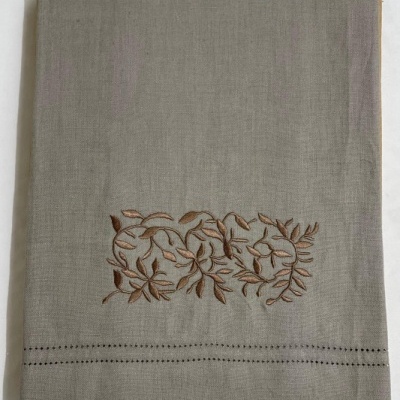 Toalha cinzenta com bordado castanho e pontos pretos na margem