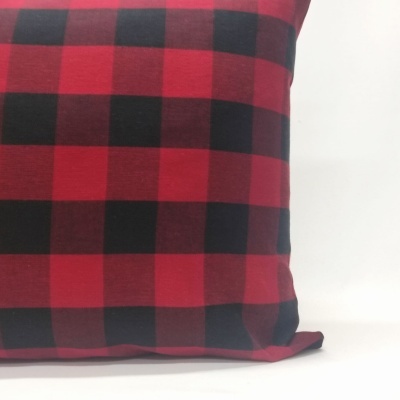 Almofada xadrez vermelho e preto sobre fundo branco