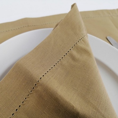 Guardanapo bege com costura sobre prato branco