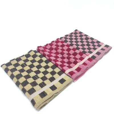 Três toalhas quadriculadas em amarelo, vermelho e rosa, e rosa e preto, sobre fundo branco