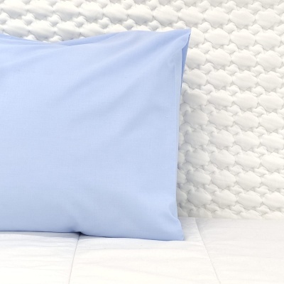 Travesseiro azul sobre colchão branco texturizado