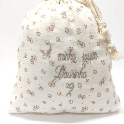 Saco de tecido branco com flores castanhas e texto bordado