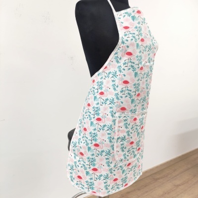 Avental floral branco com flores cor-de-rosa e folhas verdes, com bolso frontal, no manequim preto