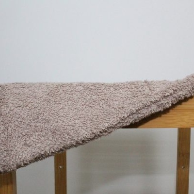 Toalha de microfibra cinza claro pendurada numa estrutura de madeira clara