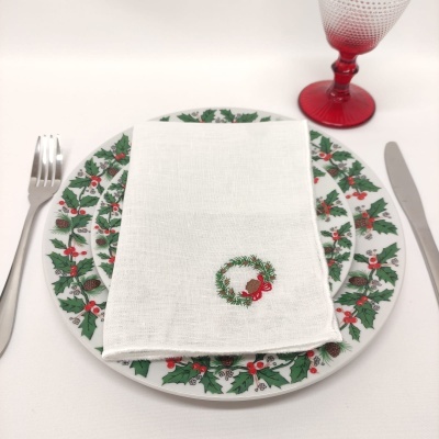 Conjunto de prato com padrão natalício, guardanapo branco bordado, talheres e copo vermelho