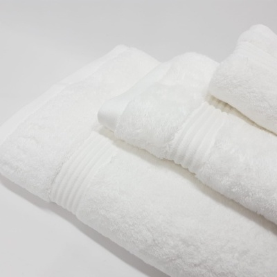 Conjunto de toalhas brancas em diferentes tamanhos com texturas e detalhes em relevo